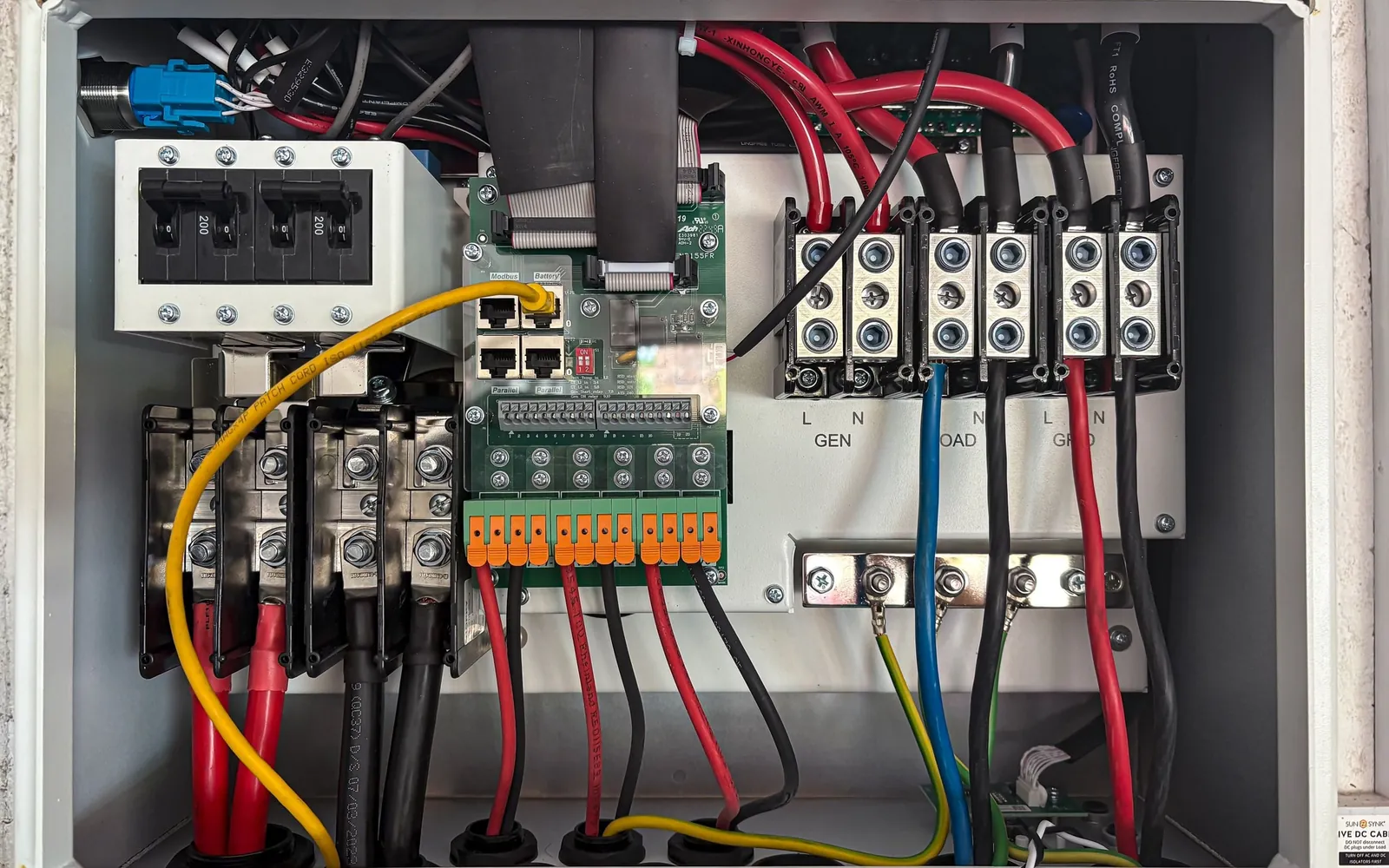 Interior of an electrical control panel with wiring and protective components.