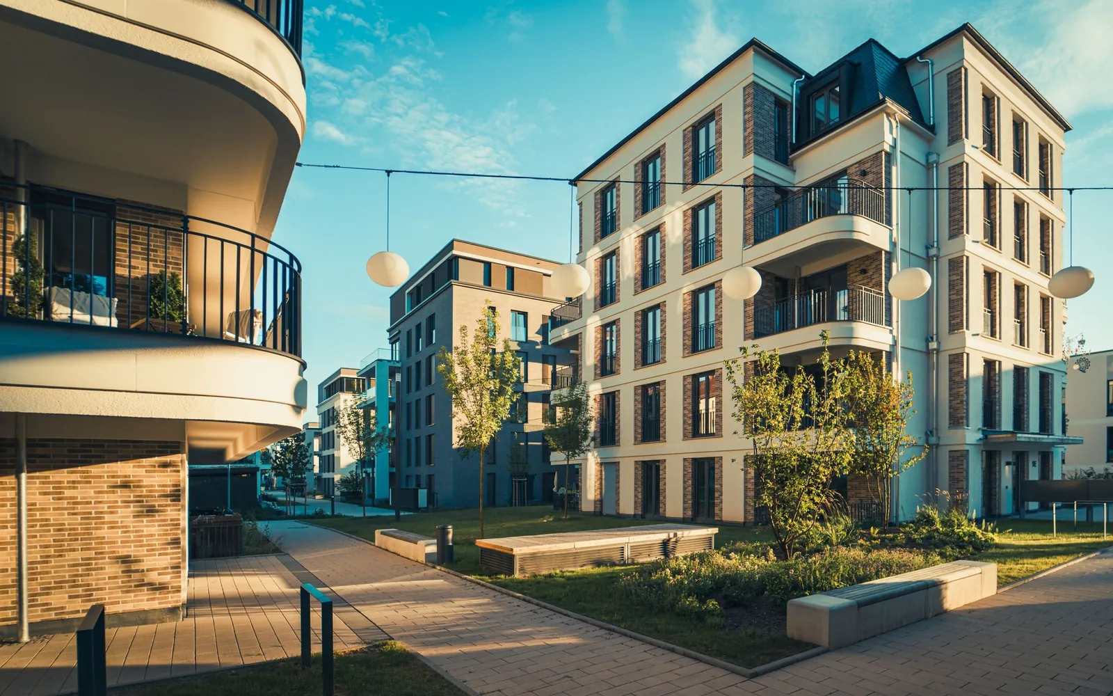 Modern multifamily apartment building with open balconies and a landscaped courtyard.